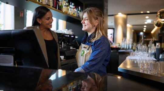 Zwei Mitarbeiterinnen im Adina Hotel an der Bar – Teamwork und Karrierechancen bei Adina Jobs.
