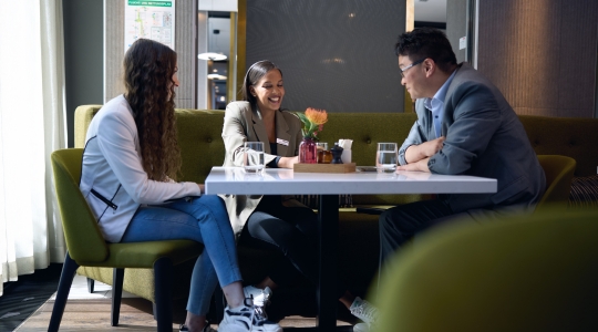 Gespräch von Mitarbeitenden und Gästen im Adina Hotel mit Karriereperspektiven bei Adina Jobs