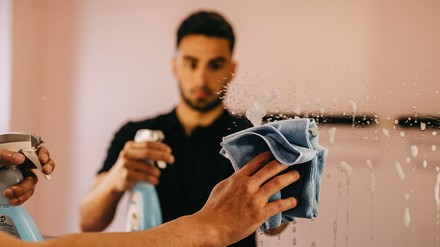 Reinigungskraft Reinigungskraft macht einen Spiegel sauber