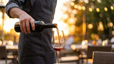 Saisonkräfte Saisonkräfte auf Abruf. Person schenkt Rotwein ins Glas