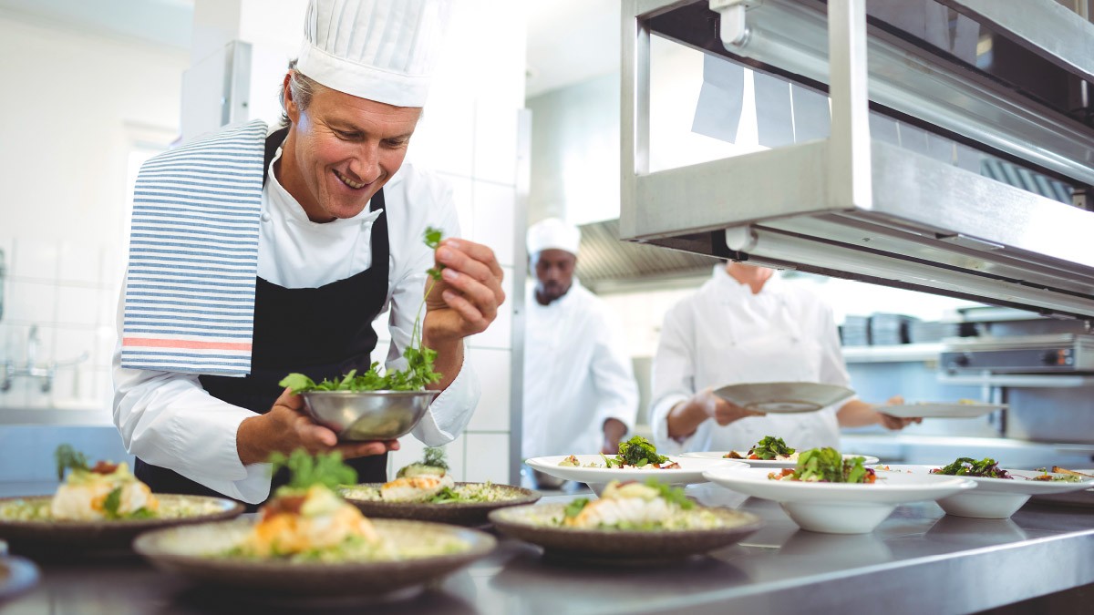 Fotos: iStockphoto Koch mit Tellern in der Küche