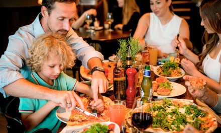 Familie sitzt gemeinsam am Tisch und isst Familie sitzt gemeinsam am Tisch und isst