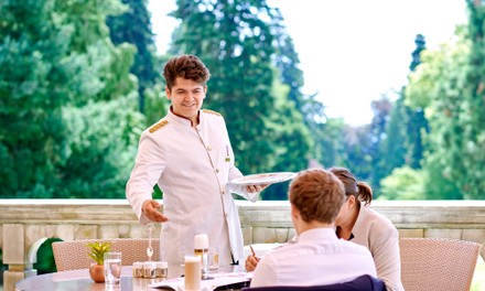 Servicekraft bei Gästen auf der Terrasse Servicekraft bei Gästen auf der Terrasse