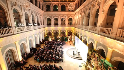 Eine Halle voller Gäste und eine Rednerbühne
