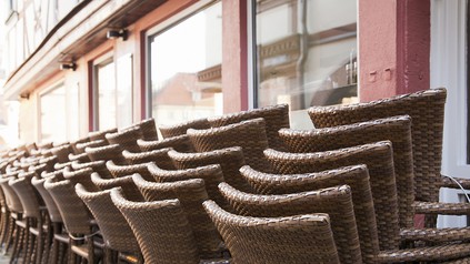 Aufgeschichtete Stühle vor einem Restaurant oder Café