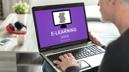 Ein Mann sitzt vor dem Laptop und hat ein E-Learning-Konzept aufgerufen
