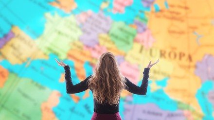 Junge Frau steht vor Weltkarte