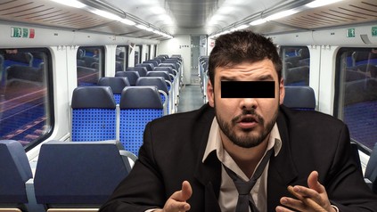 Ein Mann mit einem schwarzen Balken über den Augen sitzt mit einem Schnapsglas im Zug