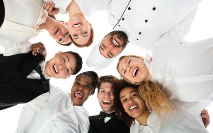 Lachende Gastro-Mitarbeiter verschiedener Nationalitäten