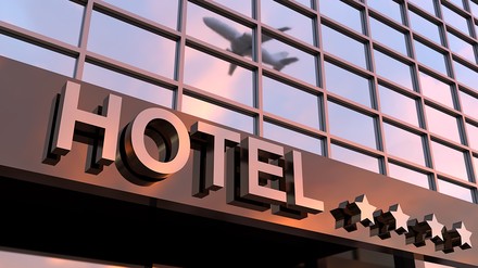 Hotelschriftzug mit vier Sternen und einem Flugzeug
