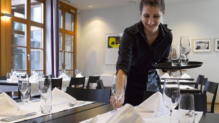 Kellnerin beim Tischdecken