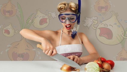 Frau mit Taucherbrille schneidet Zwiebeln