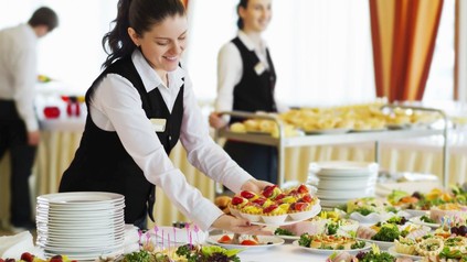 Servicekräfte dekorieren freudig ein Buffett mit köstlichen Speisen