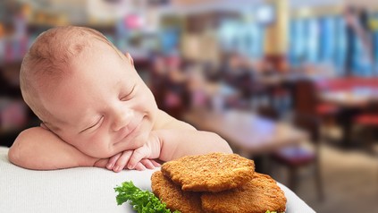 Ein neugeborenes Baby und ein Teller voller Schnitzel