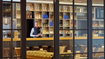 Barkeeper an der Bar des H-Hotel Leipzig mit einer Flasche in der Hand