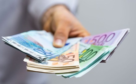 Mann hält Euro-Banknoten in der Hand