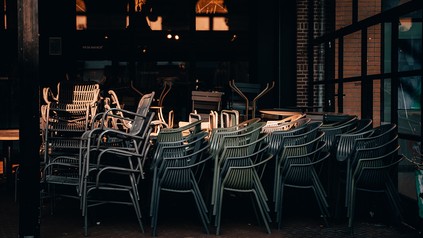 Gestapelte Stühle vor einem geschlossenen Restaurant