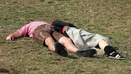 Mann in Tracht und Frau liegen auf der Wiese