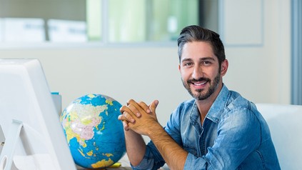 Reisebüromitarbeiter an seinem Schreibtisch