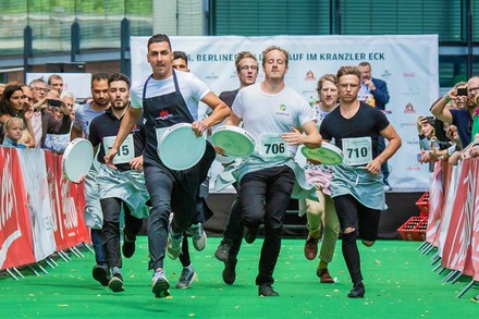 Kellern mit Tabletts in der Hand liefern sich ein Rennen