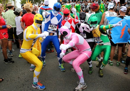 Eine Gruppe als Superhelden verkleideter Läufer auf der Marathonstrecke