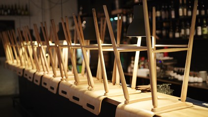 Barstühle sind umgedreht auf einen Bartresen gestellt