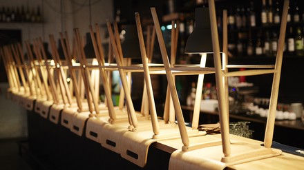 Barstühle sind umgedreht auf einen Bartresen gestellt