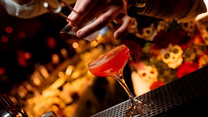 Ein Cocktail in einer Bar wird eingeschenkt.