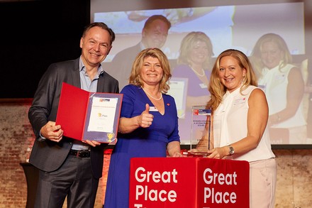 Drei Almdudler-Mitarbeiter nehmen urkunden entgegen