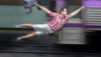 Ein Mann hät sich an einem fahrenden Zug fest