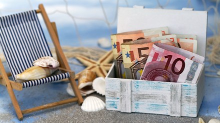 Eine Kiste voller Geld am Strand