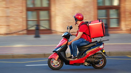 Lieferdienst-Mitarbeiter auf einem Roller