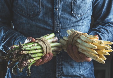 Mann hält zwei Spargelbündel