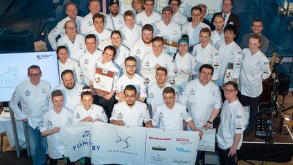 Eine Vielzahl von Patissiers mit Urkunden in der Hand