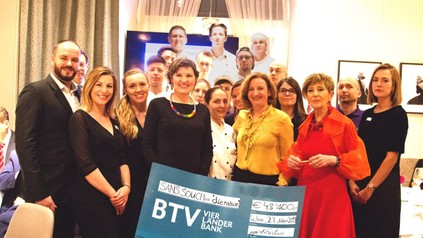 Hotel-Mitarbeiter präsentieren den Wohltätigkeits-Scheck