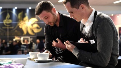 Zwei Männer betrachten eine Tasse Kaffee