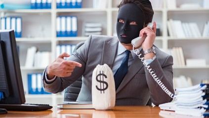 Geschäftsmann mit Maske in Büro an Telefon