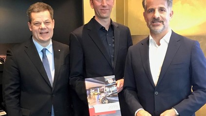 Drei Männer stellen neu erschienenen Marktbericht vor