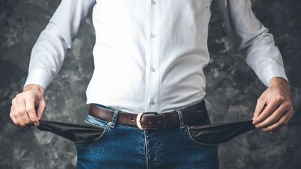 Mann zeigt seine leeren Hosentaschen