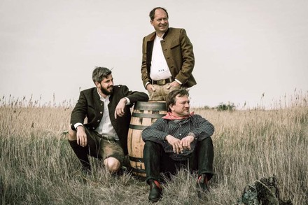 Drei Männer in Tracht auf Wiese