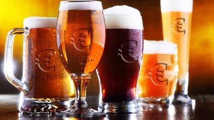 Ein paar Biergläser mit Euro-Symbolen auf einem Tisch