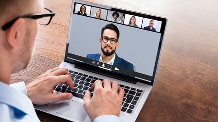 Geschäftsmann nimmt an Online-Konferenz über den Laptop teil