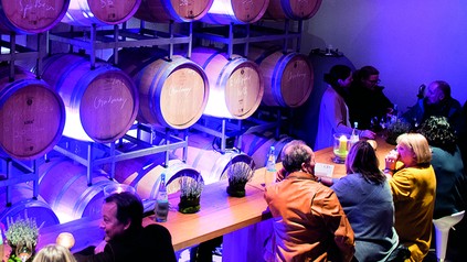 Mehrere Genießer tafeln in einem Weinkeller