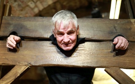 Mann in einem hölzernen Pranger