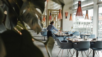 Kellnerin deckt Tische ein