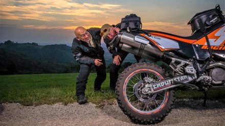 2 Biker begutachten den Auspuff eines Motorrades