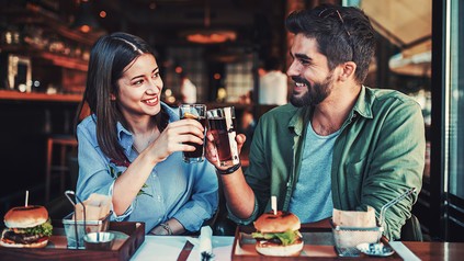 Ein Paar stößt im Restaurant mit alkoholfreien Getränken an