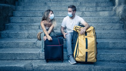 Traurige und frustrierte Urlauber auf einer Steintreppe sitzend