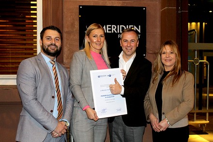 Eine Gruppe Le Meridien-Mitarbeiter mit Urkunde in der Hand