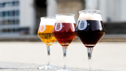 Drei verschiedene Craftbiere in Gläsern auf Asphalt